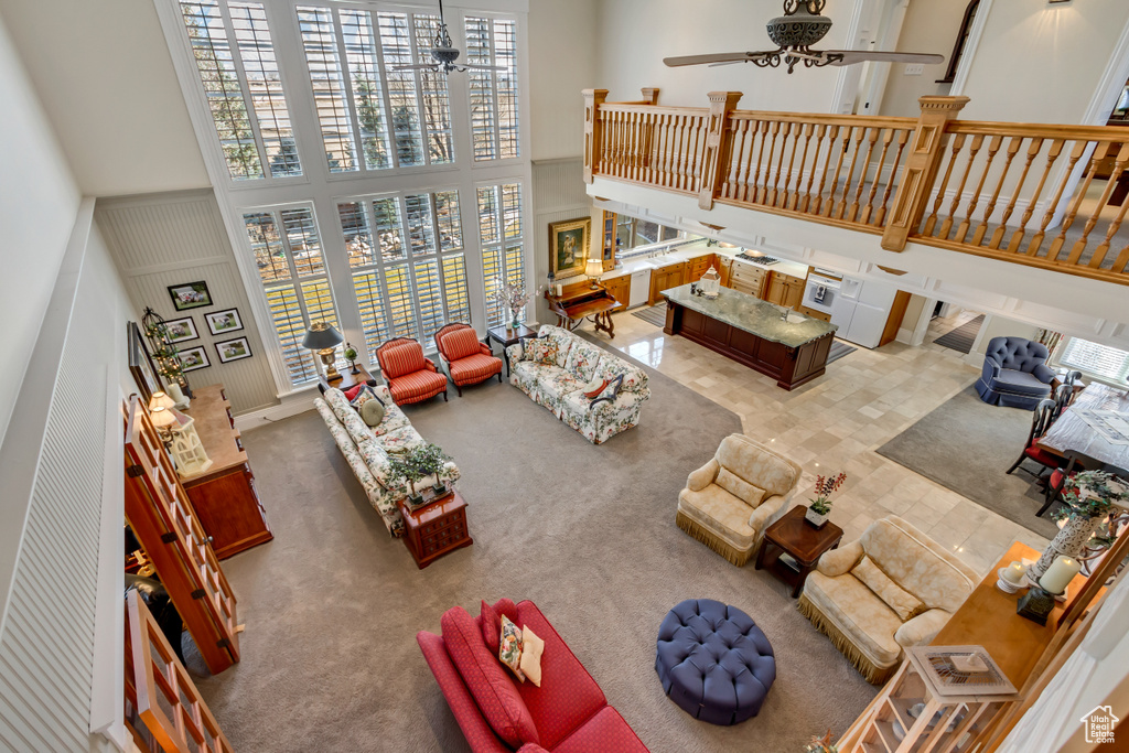 Living room featuring a ceiling fan and a towering ceiling