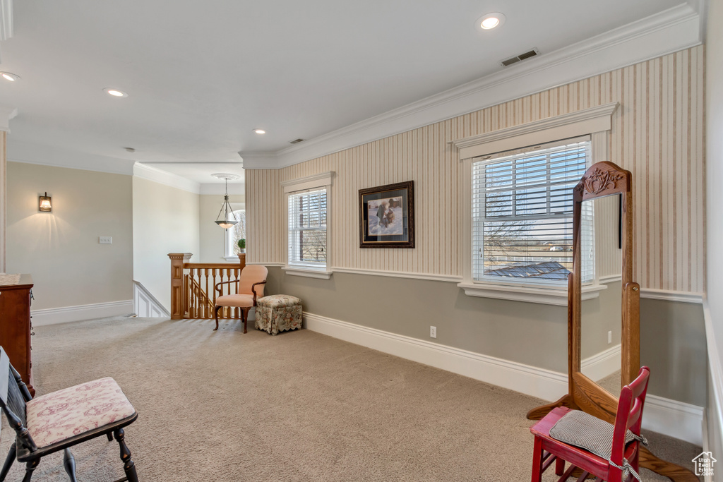 Sitting room with carpet, crown molding, visible vents, an upstairs landing, and baseboards