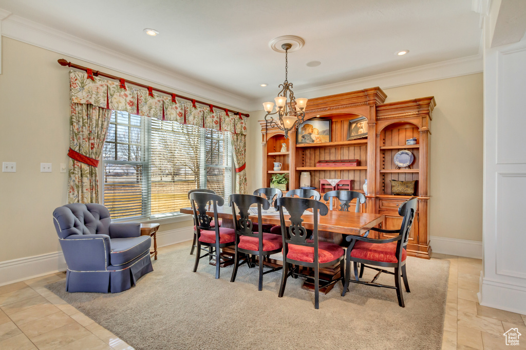 Dining space featuring baseboards, ornamental molding, and a chandelier