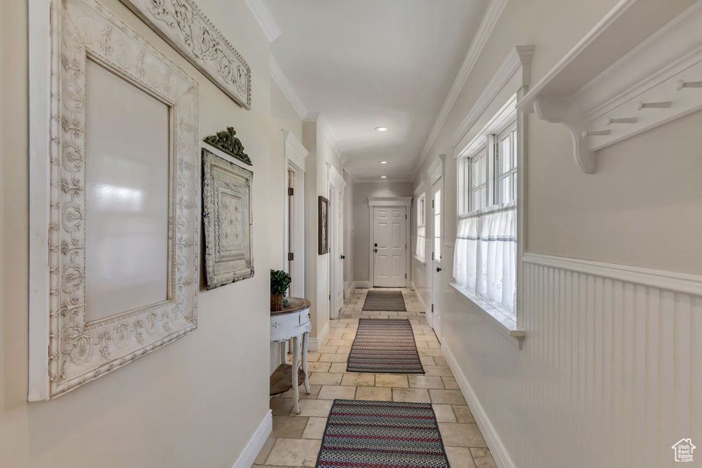 Hall featuring recessed lighting, baseboards, ornamental molding, wainscoting, and stone tile flooring