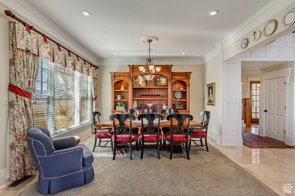 Dining area featuring an inviting chandelier, ornamental molding, and recessed lighting