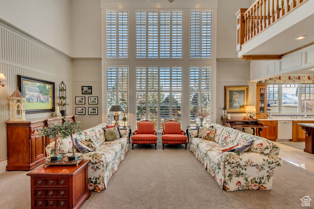 Living room featuring light carpet and a high ceiling