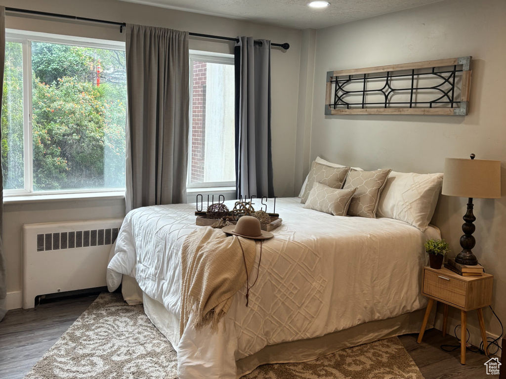 Bedroom featuring radiator, wood finished floors, a textured ceiling, and recessed lighting