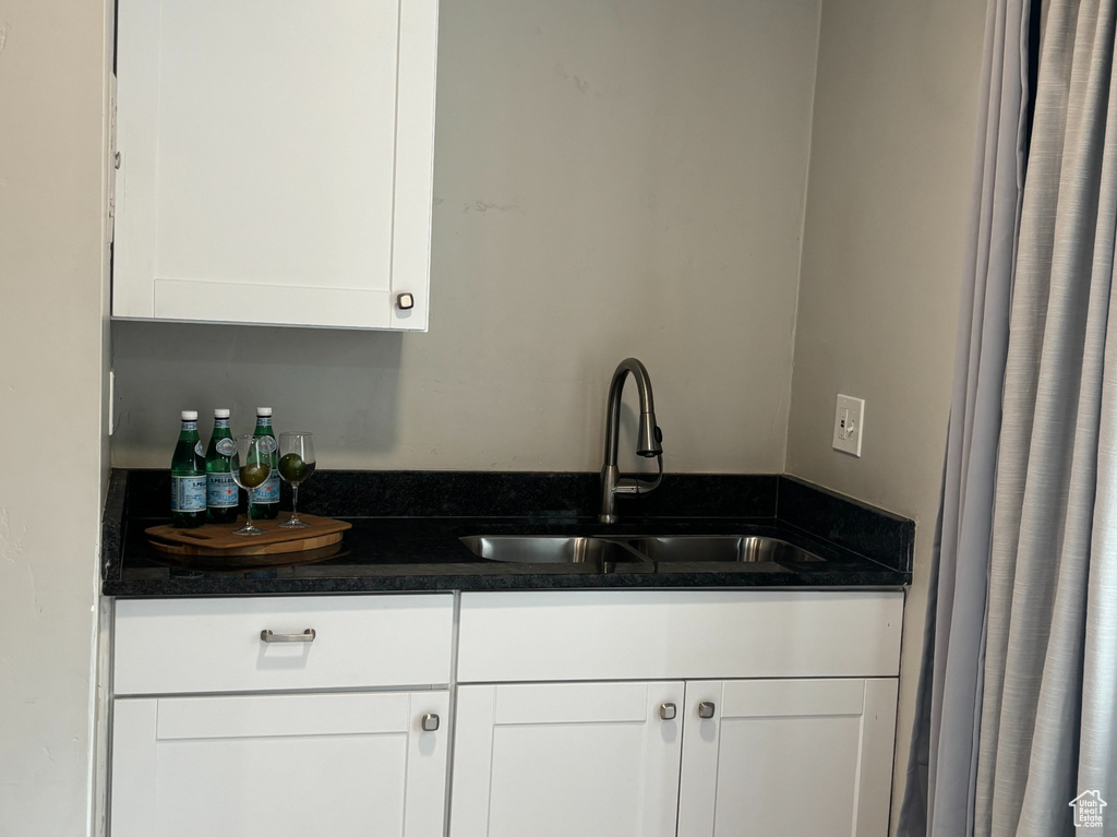 Bar featuring a sink and light wood-type flooring