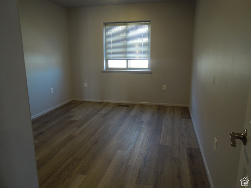 Spare room with visible vents, baseboards, and wood finished floors