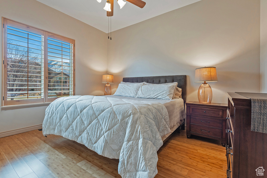 Bedroom featuring light wood-style flooring, baseboards, and ceiling fan