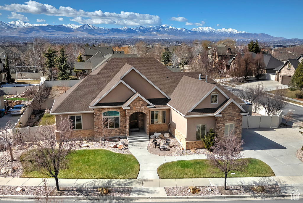 View of front facade featuring stone siding, a residential view, a mountain view, and stucco siding