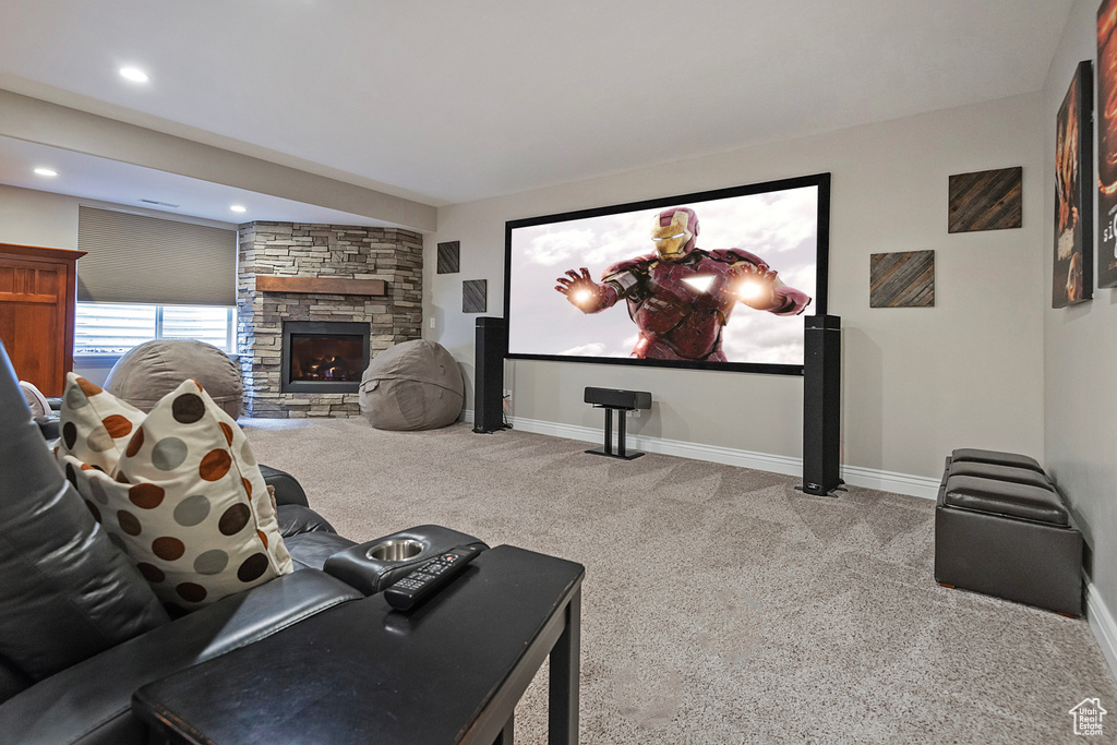 Cinema room featuring recessed lighting, a fireplace, baseboards, and light colored carpet