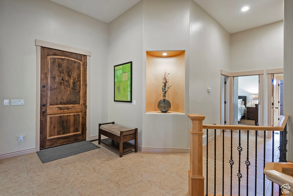 Foyer entrance with a high ceiling, recessed lighting, and baseboards