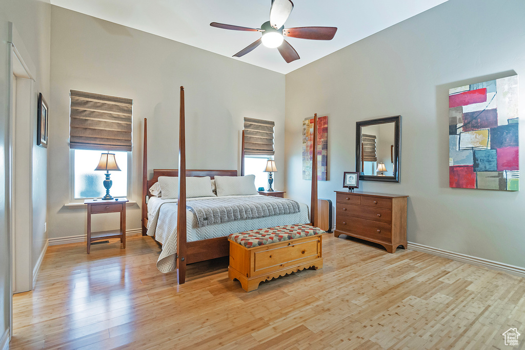 Bedroom featuring a ceiling fan, light wood-style flooring, and baseboards