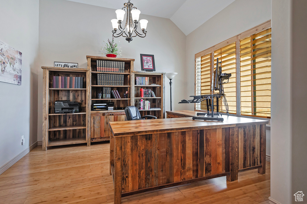 Home office with lofted ceiling, baseboards, a notable chandelier, and light wood-style floors