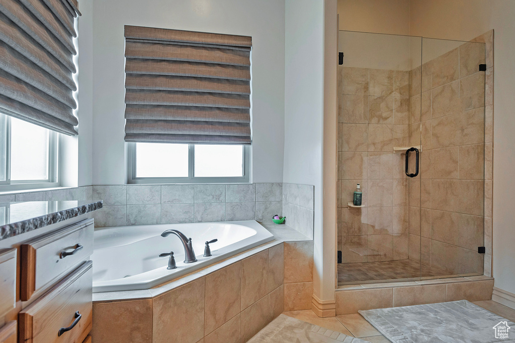 Full bathroom featuring a stall shower, vanity, a bath, and tile patterned floors