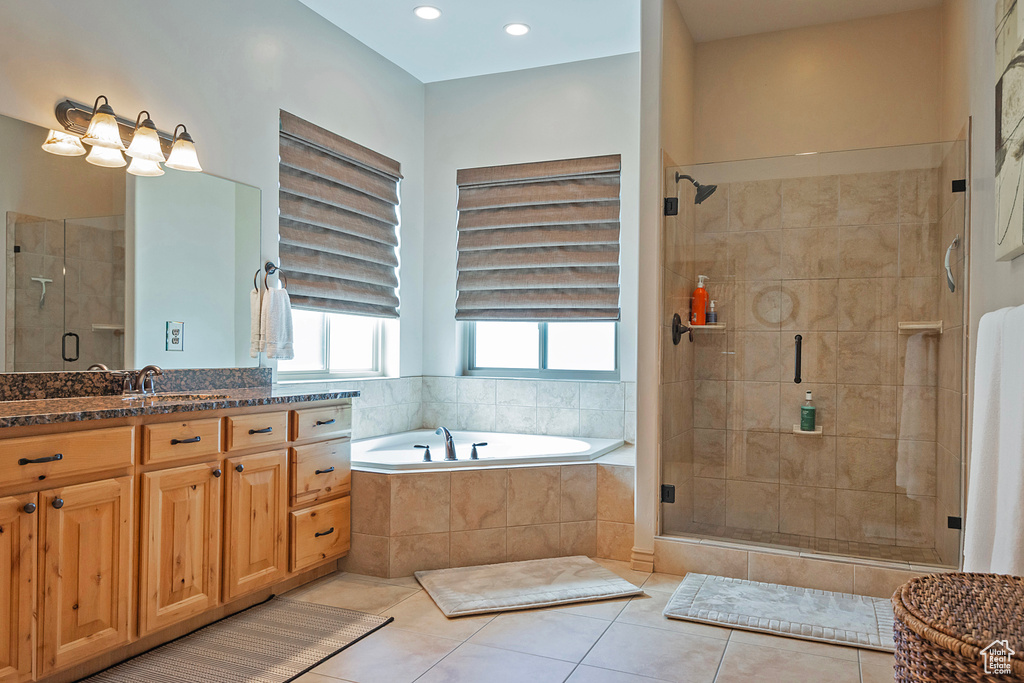 Bathroom featuring a stall shower, vanity, a bath, and tile patterned floors