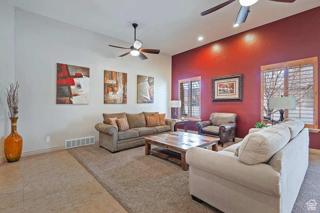 Living room with a ceiling fan, visible vents, baseboards, and light tile patterned floors