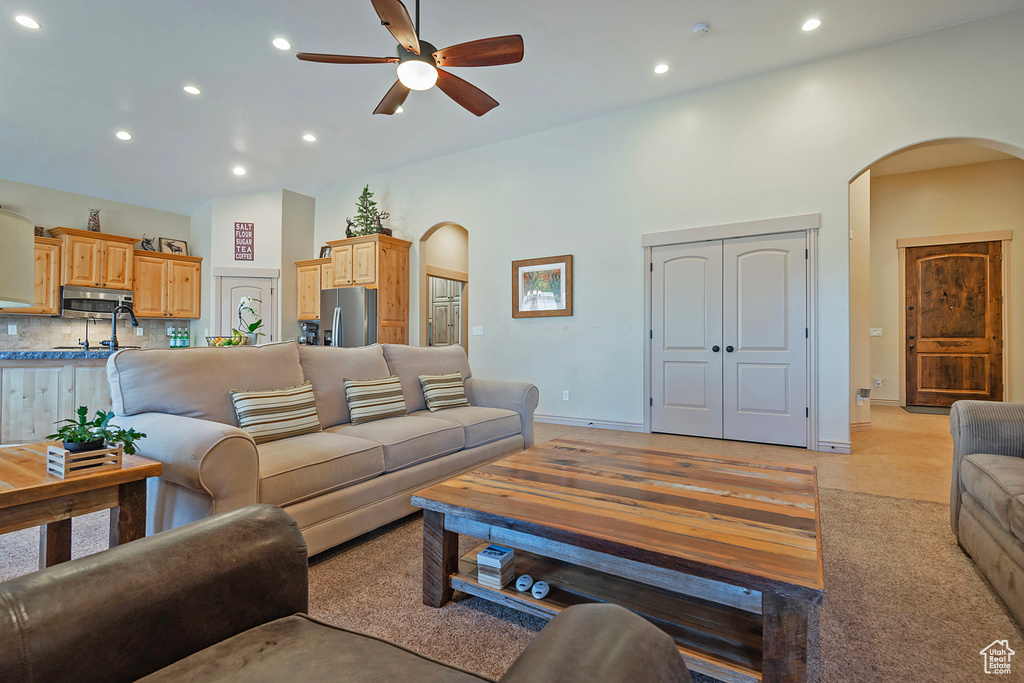 Living area with a high ceiling, arched walkways, and recessed lighting