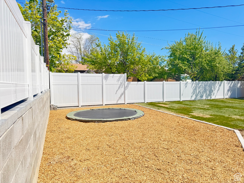 View of yard featuring a fenced backyard and a trampoline