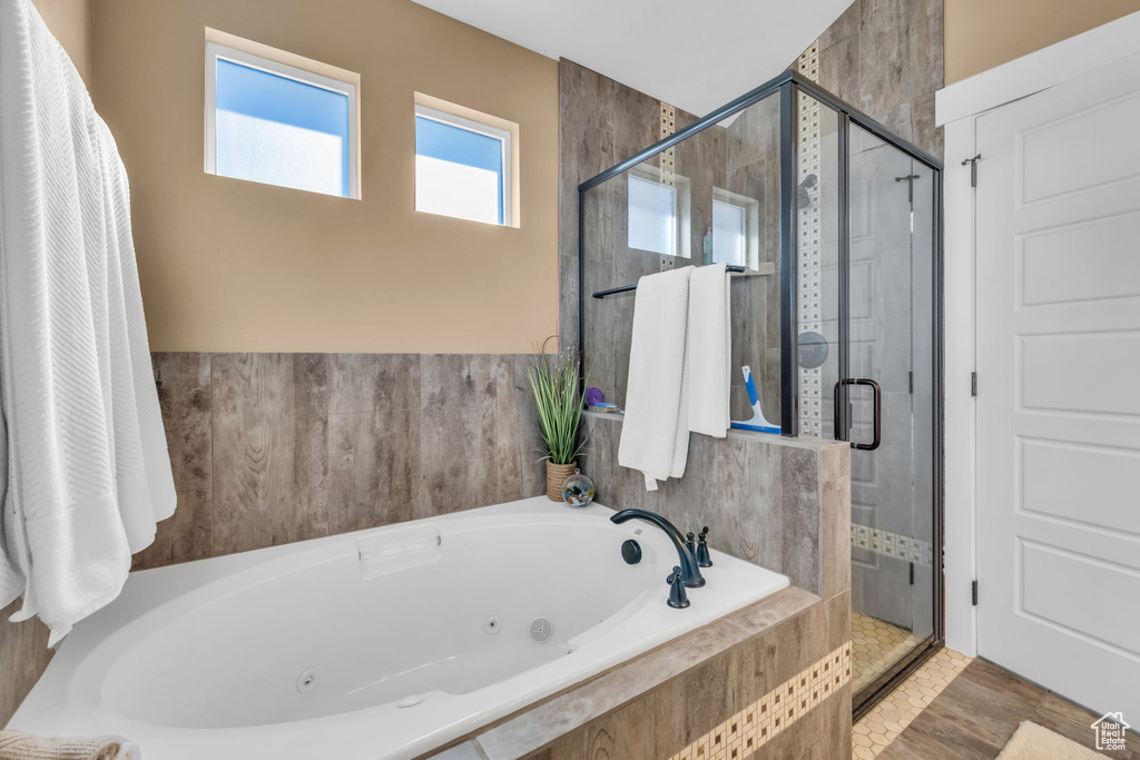 Full bath with a jetted tub and a stall shower