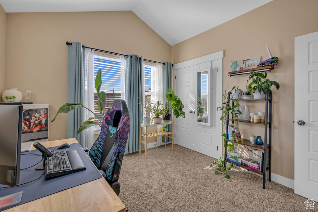 Carpeted home office featuring lofted ceiling and baseboards