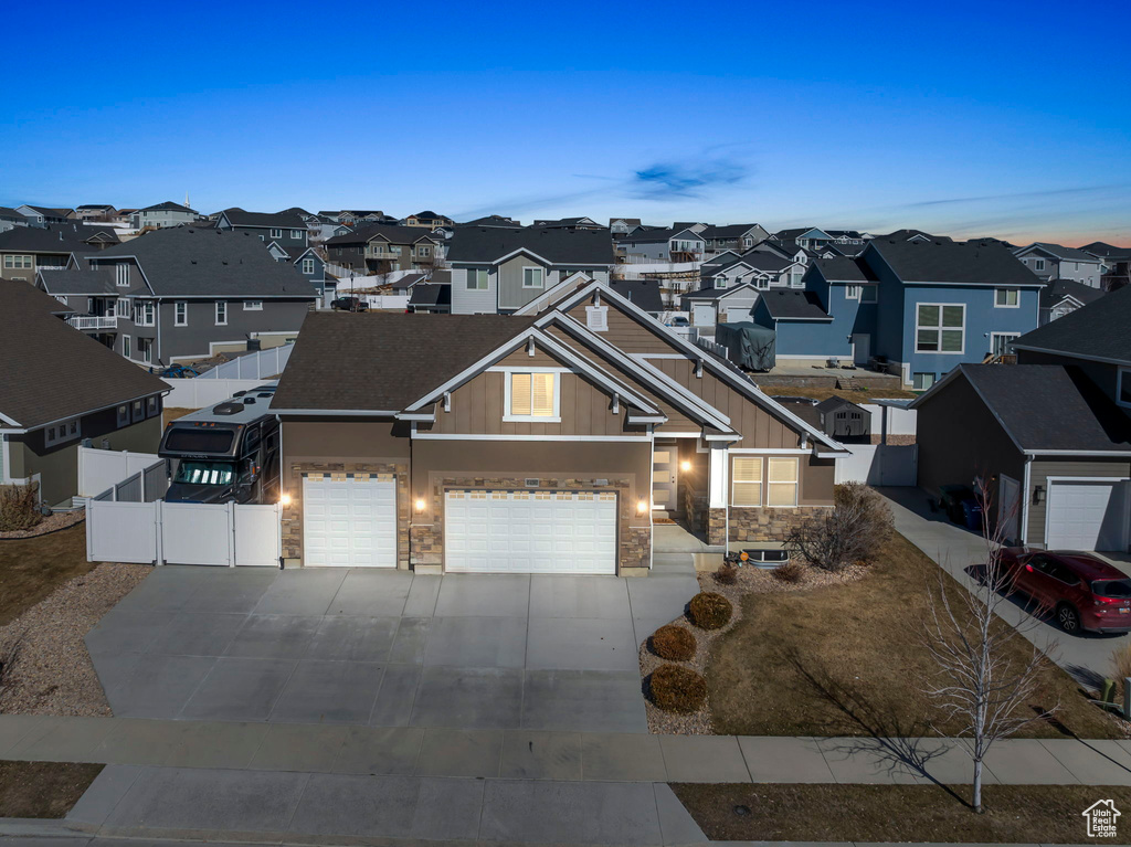 View of front of house with a garage, concrete driveway, a residential view, a gate, and fence