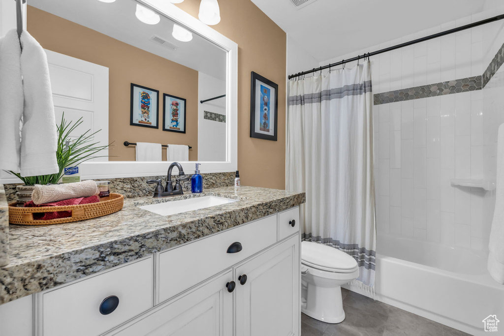 Full bathroom with tile patterned flooring, toilet, vanity, visible vents, and shower / bath combination with curtain