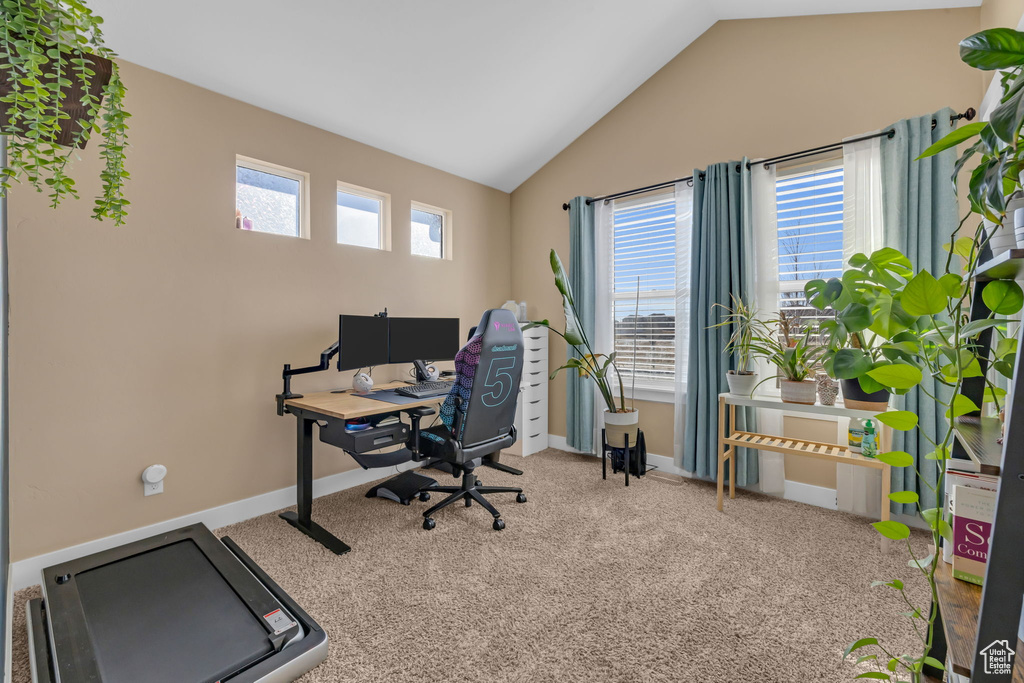 Home office with lofted ceiling, carpet floors, and baseboards