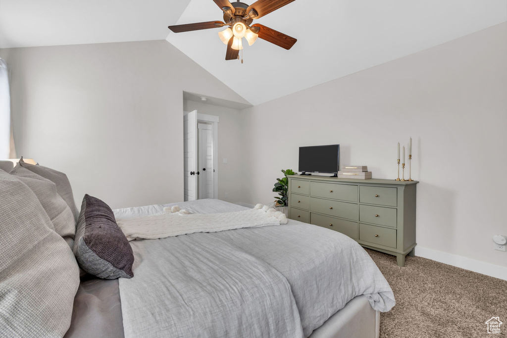 Bedroom with ceiling fan, baseboards, vaulted ceiling, and light colored carpet