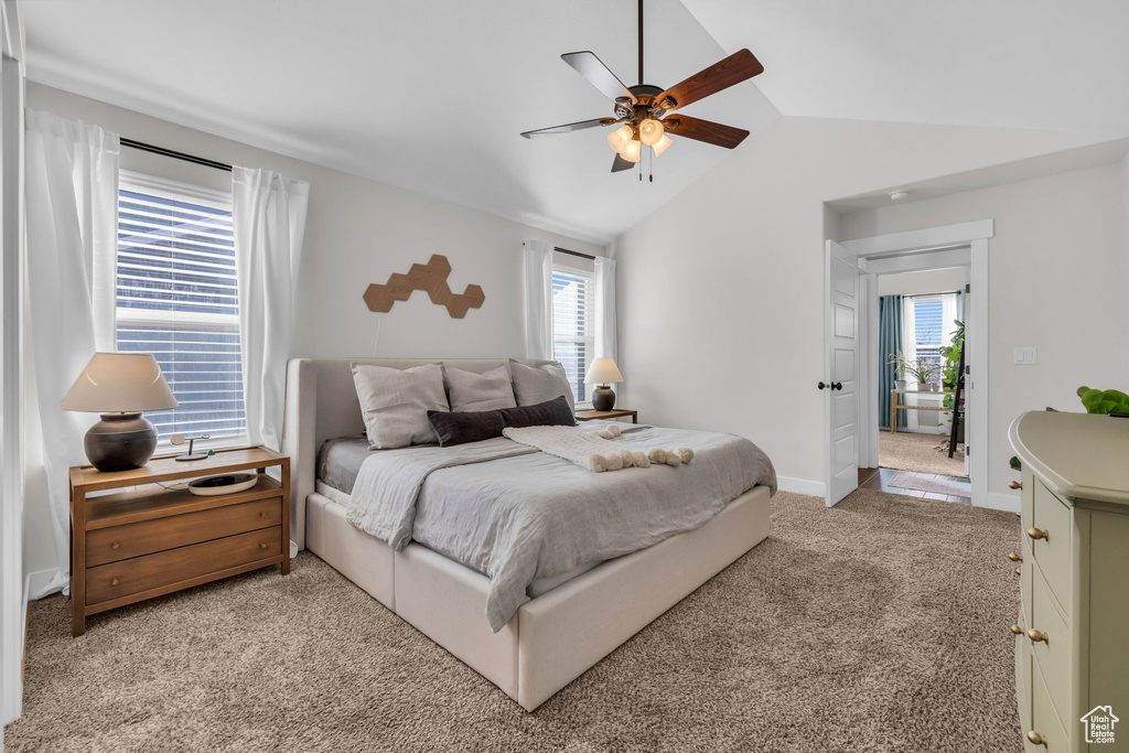 Bedroom with a ceiling fan, lofted ceiling, light carpet, and baseboards