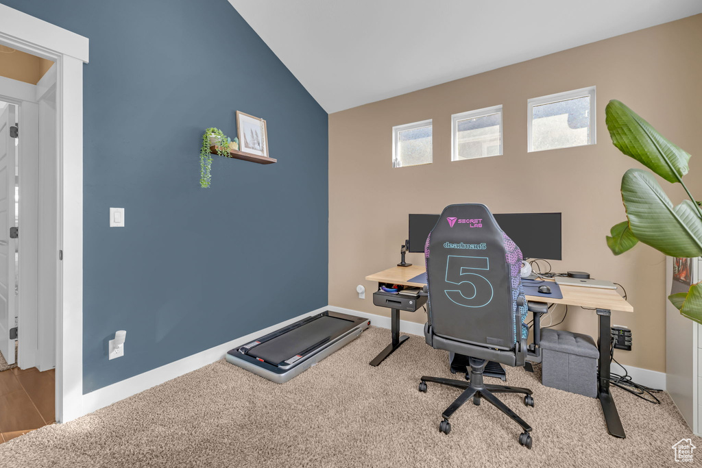 Home office with carpet flooring, vaulted ceiling, and baseboards