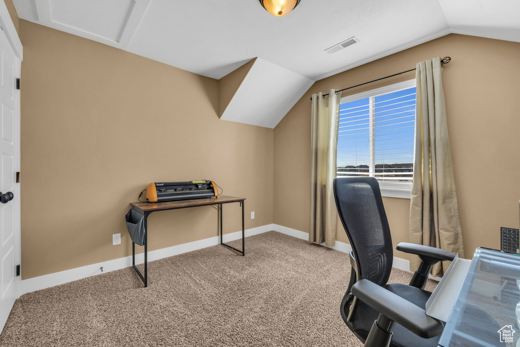 Home office featuring visible vents, baseboards, vaulted ceiling, and carpet flooring