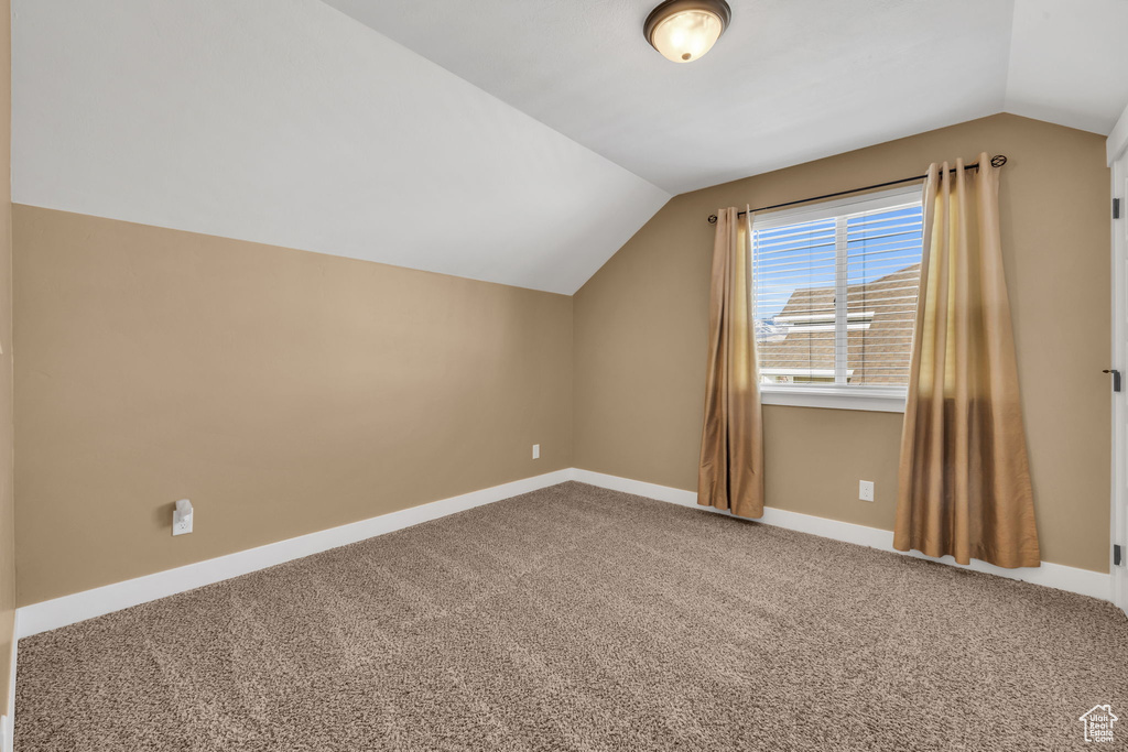 Additional living space featuring lofted ceiling, carpet flooring, and baseboards