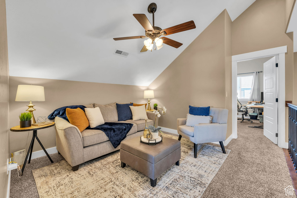 Living room featuring lofted ceiling, light colored carpet, visible vents, and baseboards