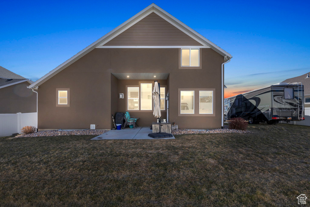 Back of house with a patio, a yard, fence, and stucco siding