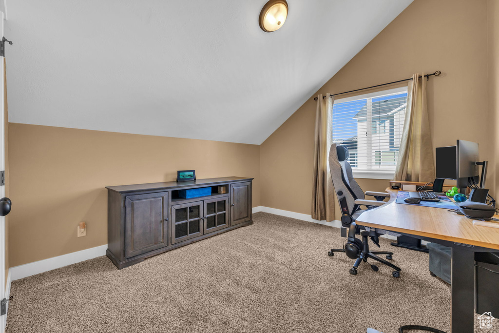 Office featuring light carpet, vaulted ceiling, and baseboards