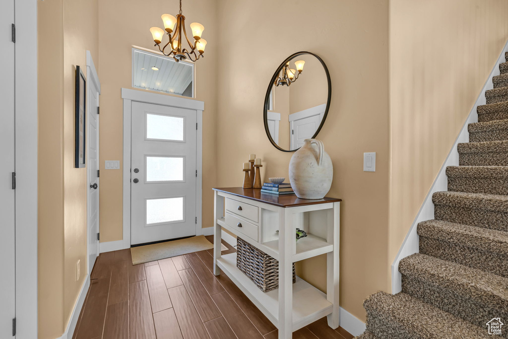 Foyer featuring stairs, wood finish floors, plenty of natural light, and baseboards