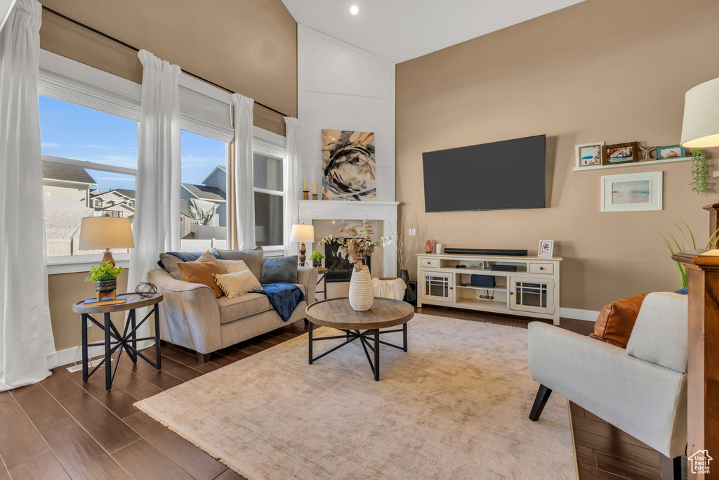 Living area with wood tiled floor, baseboards, and vaulted ceiling