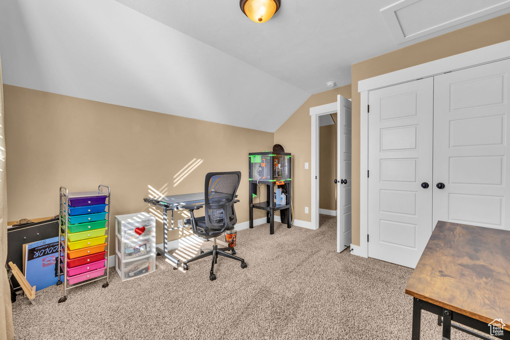 Office space with lofted ceiling, carpet floors, and baseboards