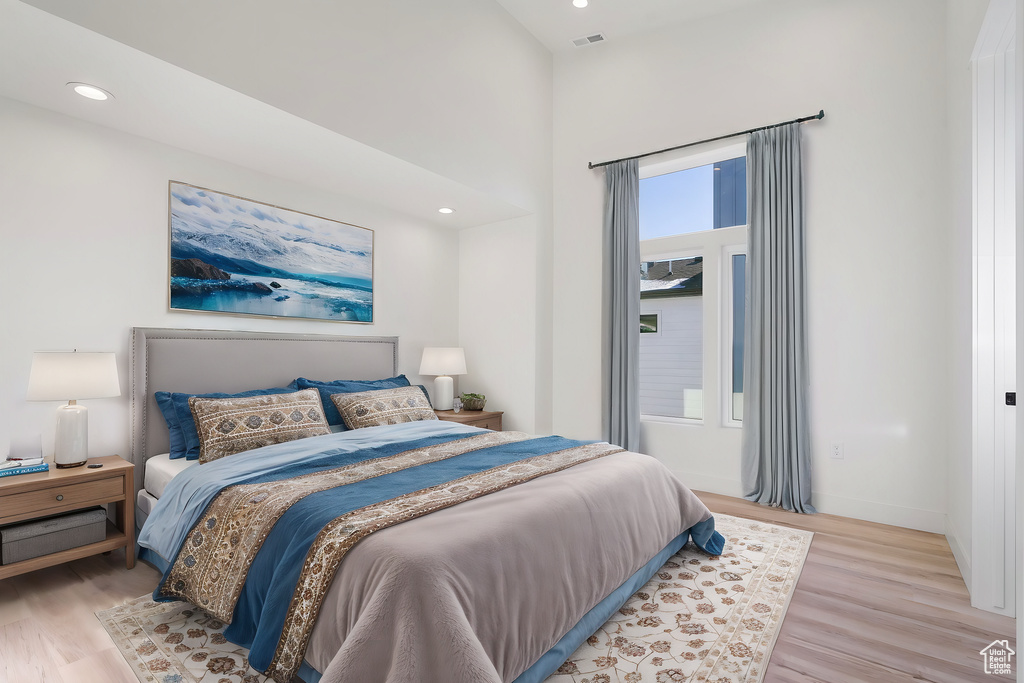 Bedroom with light wood-style floors, baseboards, visible vents, and recessed lighting