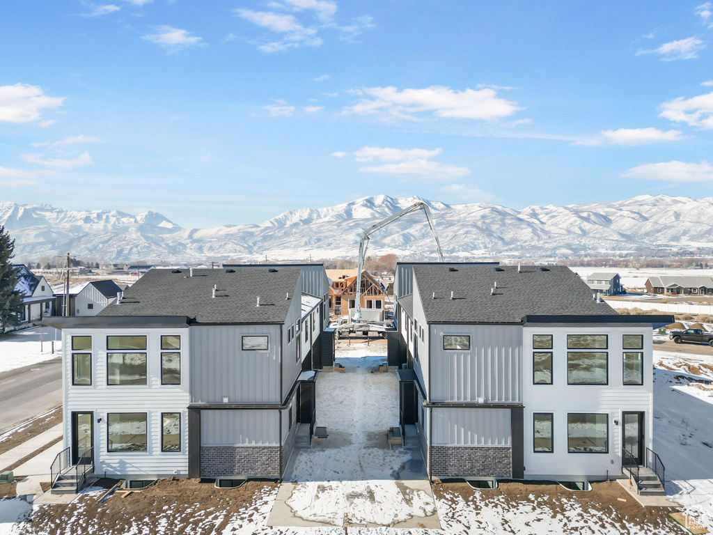 Exterior space featuring a mountain view and roof with shingles