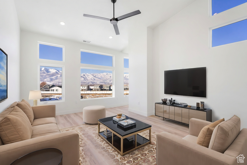 Living room with baseboards, visible vents, wood finished floors, and recessed lighting