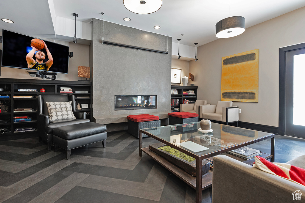 Living room with a fireplace, baseboards, and recessed lighting