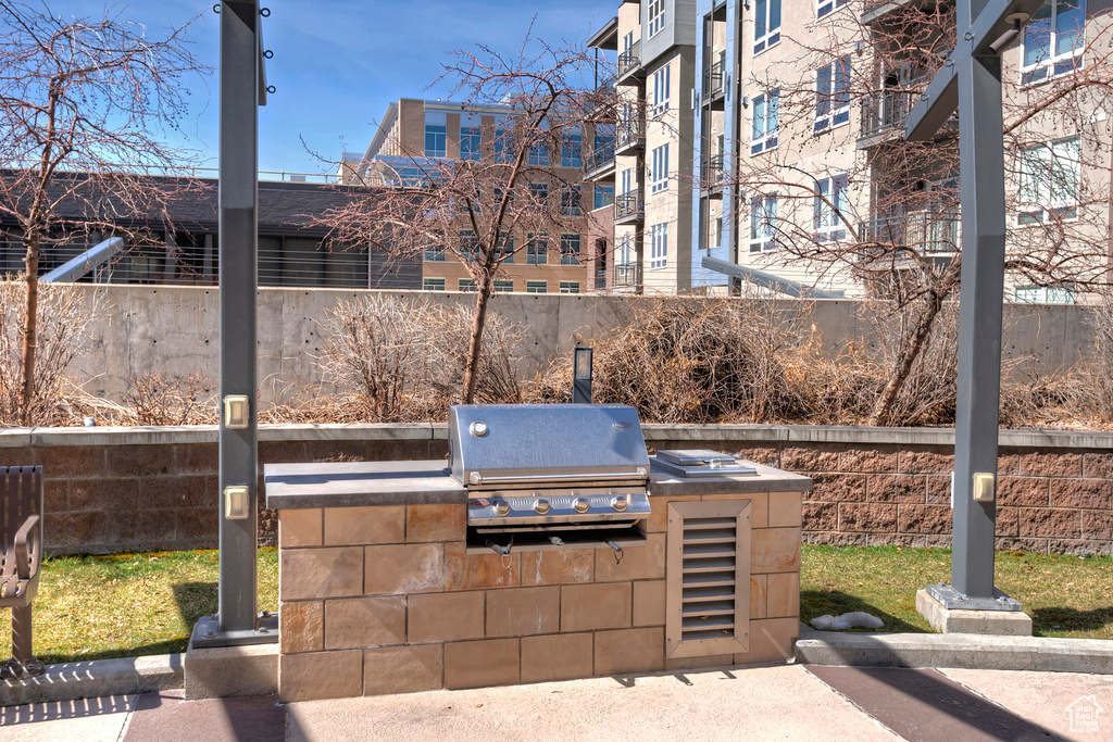 View of patio with an outdoor kitchen, grilling area, and fence