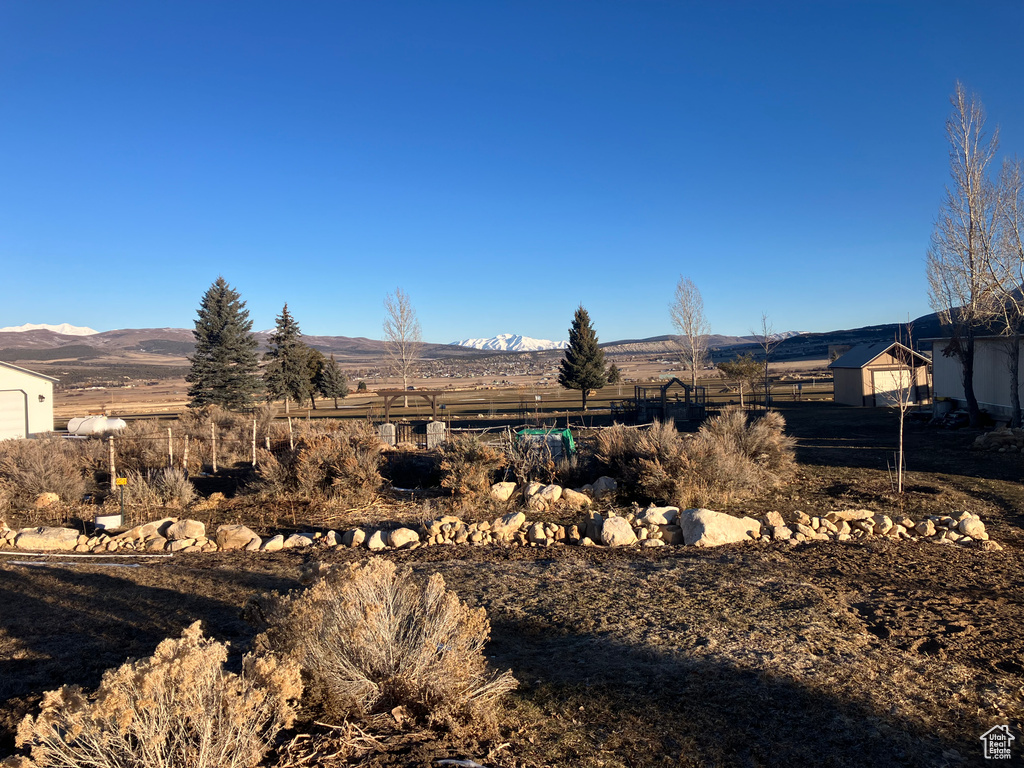 View of yard featuring a mountain view and fence