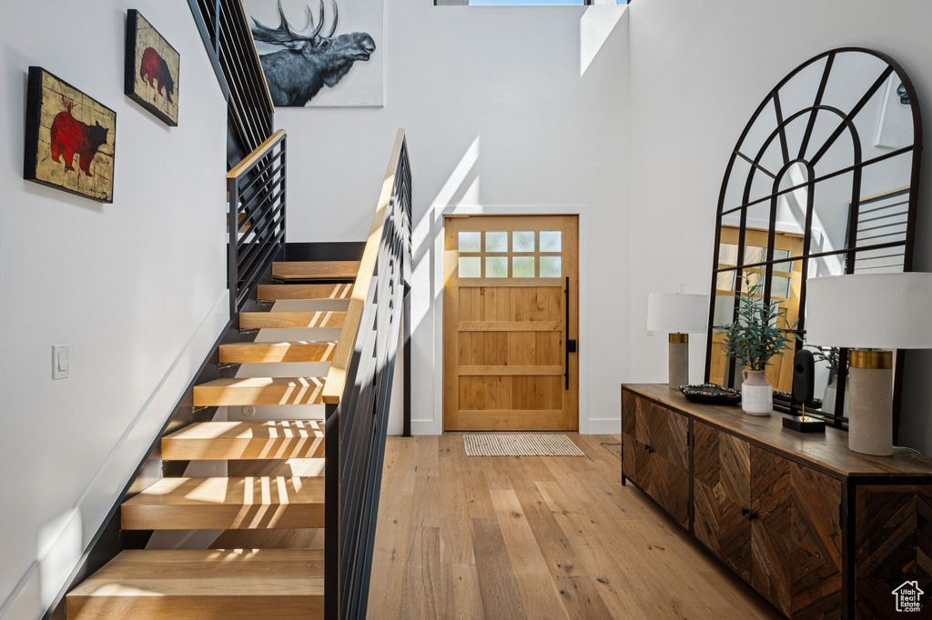 Entrance foyer featuring a high ceiling, hardwood / wood-style floors, and stairs