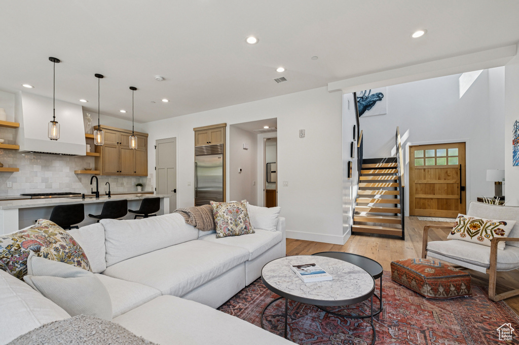 Living area featuring light wood-style flooring, stairway, and recessed lighting