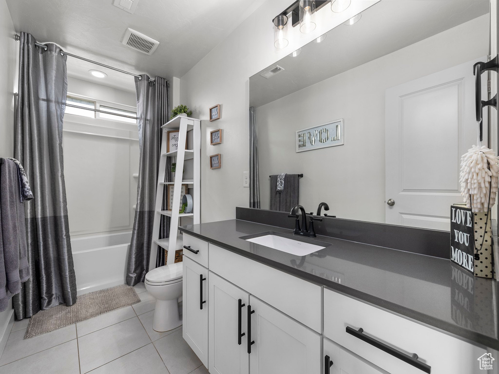 Bathroom featuring visible vents, shower / bathtub combination with curtain, toilet, vanity, and tile patterned flooring