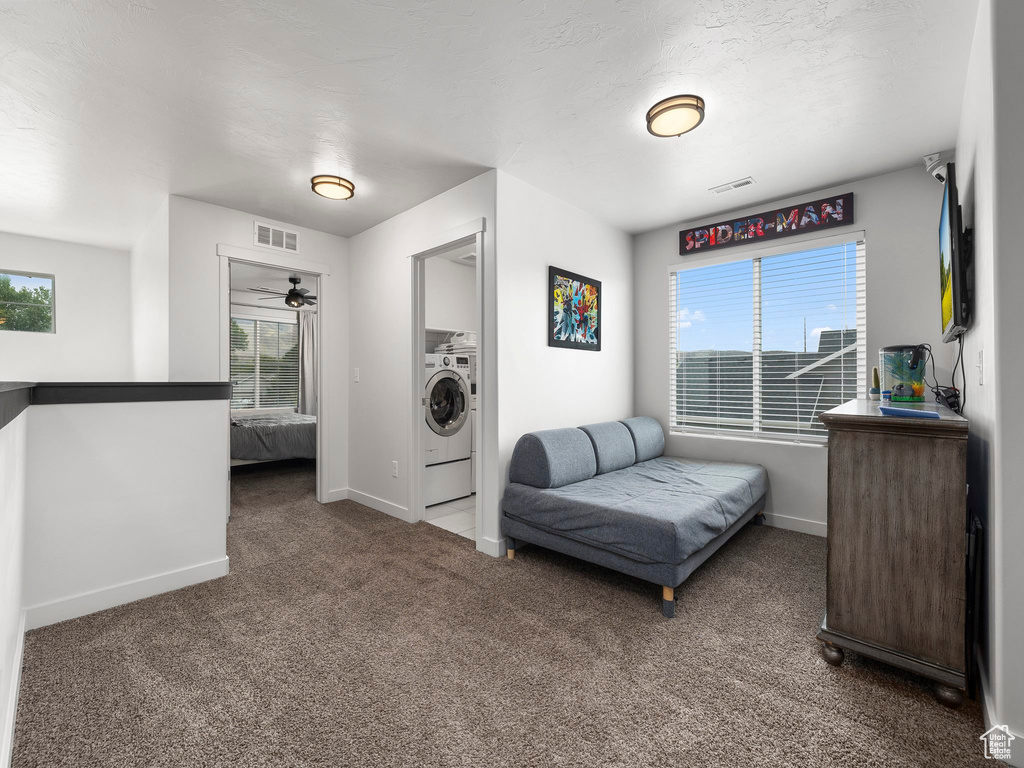 Carpeted bedroom with washer / dryer, multiple windows, and visible vents