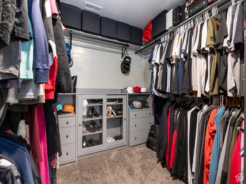 Walk in closet featuring visible vents and carpet flooring