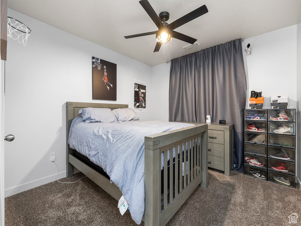 Carpeted bedroom featuring a ceiling fan, visible vents, and baseboards