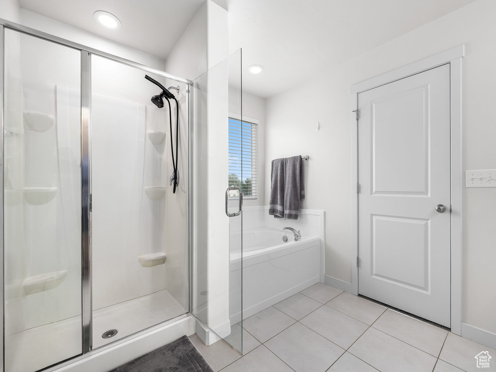 Full bathroom featuring baseboards, a shower stall, a bath, and tile patterned floors