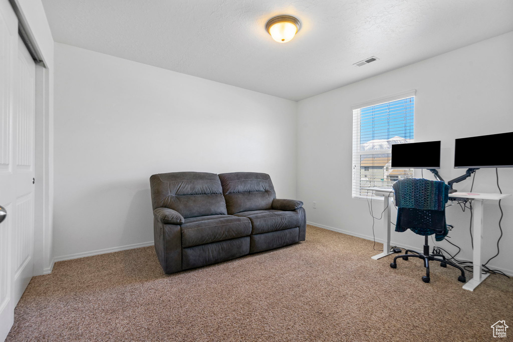 Carpeted home office featuring visible vents and baseboards